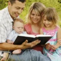 young family reading bible nature 41937327 1
