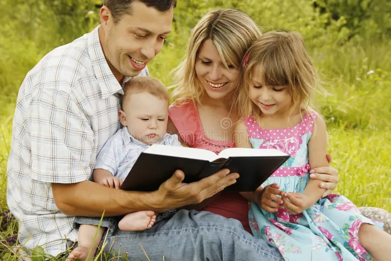 young family reading bible nature 41937327 1